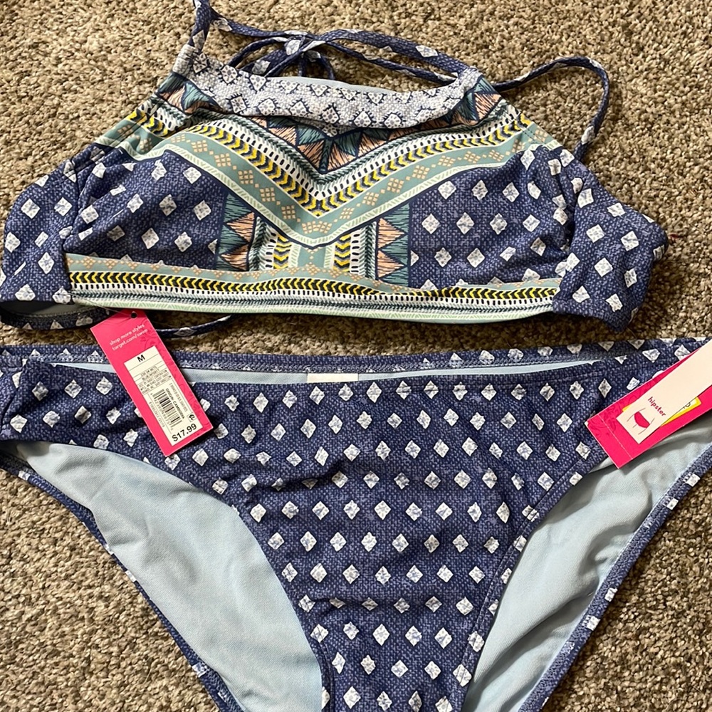 The top is adjustable because it’s all strings. Top size Medium. Bottoms size XL